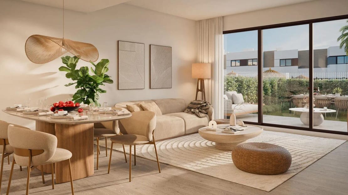 Stylish cream-colored living and dining area with earthy tones, modern decor, and large sliding glass doors opening to a private garden